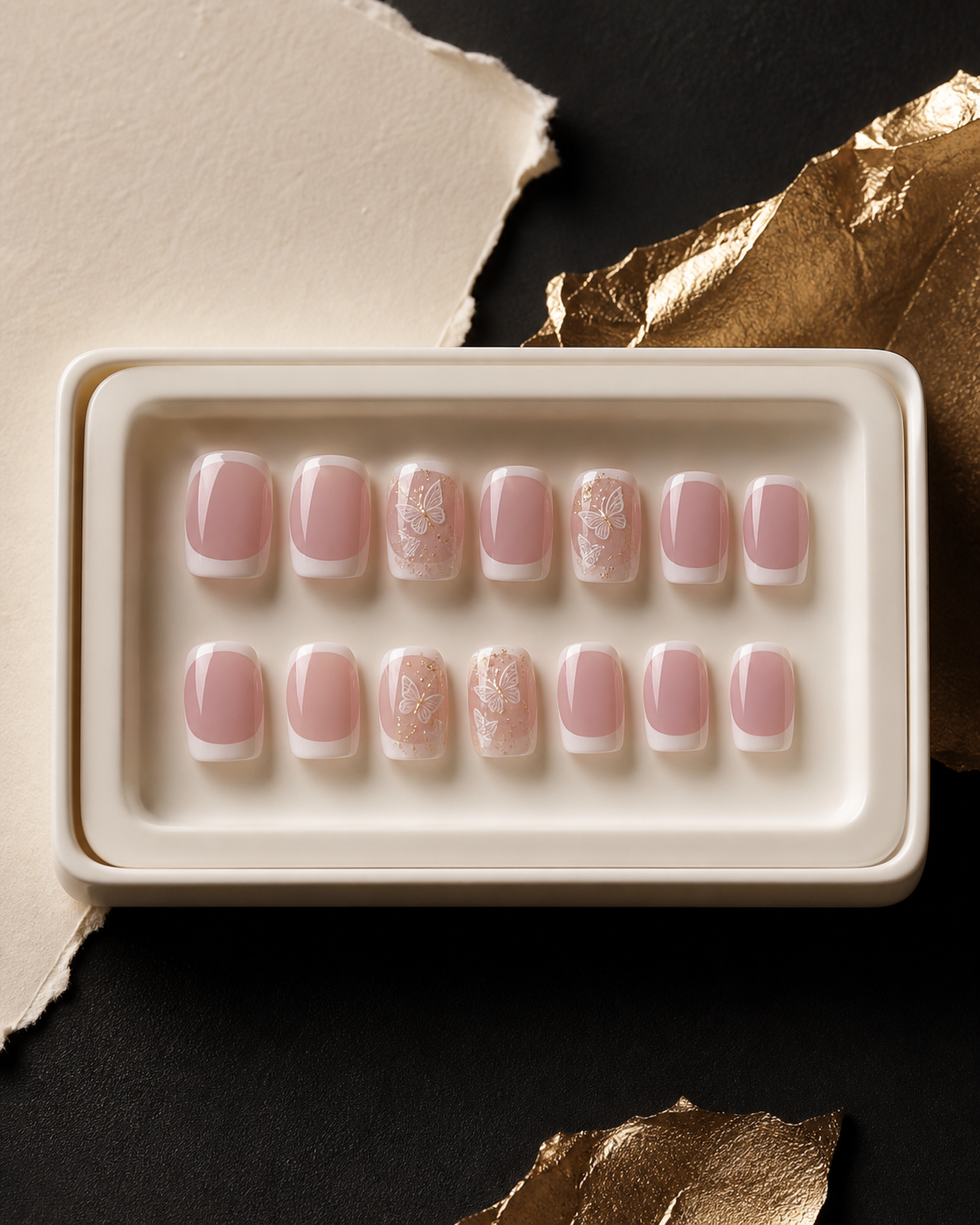 White French press-on nails with butterfly and gold details in an ivory presentation box